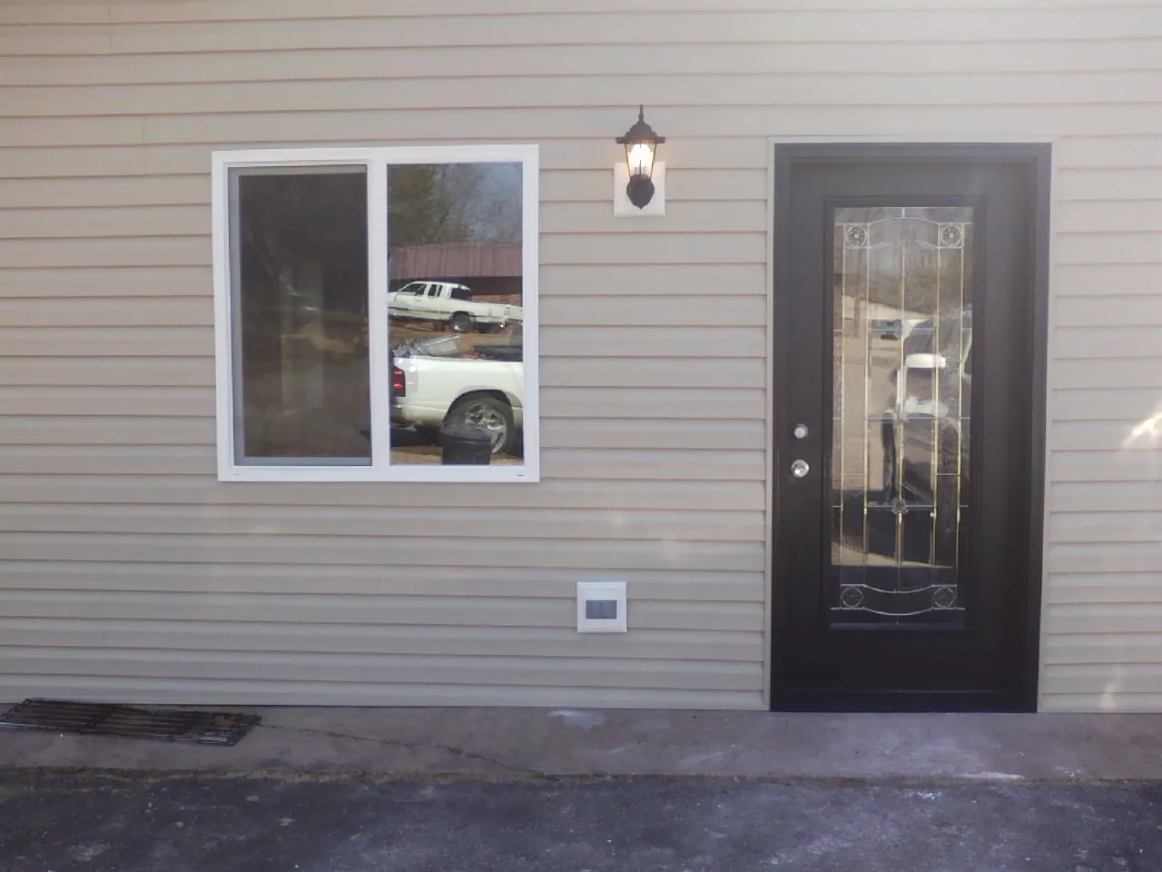 New siding, window and entry door on the side of an addition in Belfast