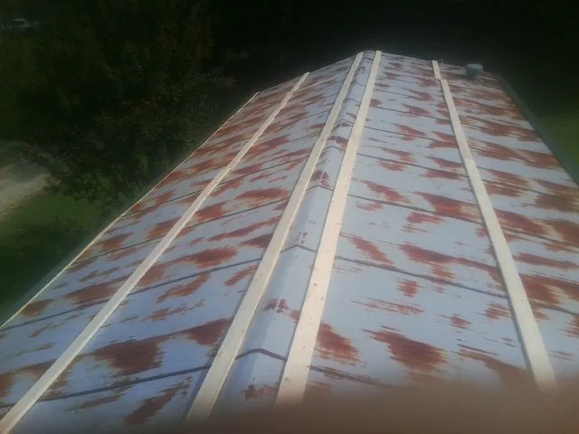 Rusted metal roof panels with new wood purlins before replacement — Storm Damage Roof Repair in Belfast by Roofing Brothers